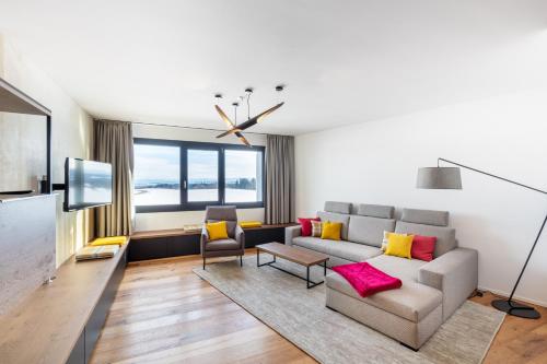 a living room with a couch and a tv at Macardo Premium B&B in Bissegg