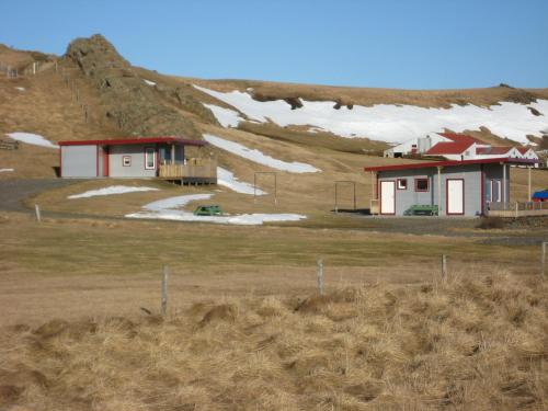 a house in the middle of a field with snow at Ásbrandsstadir Cottages in Vopnafjörður