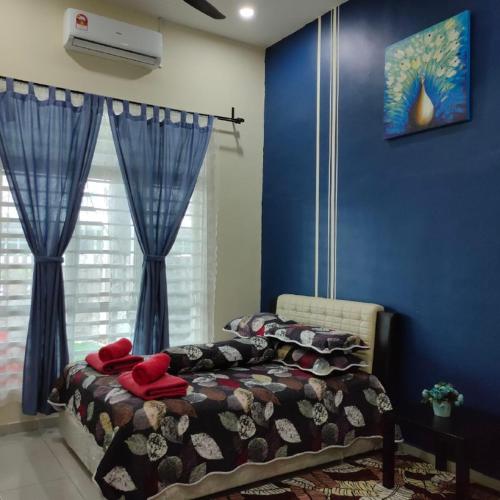 a bedroom with a bed with blue walls at D'Q Putra Homestay Melaka (Unit AMAR) in Melaka