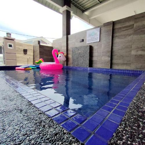 una piscina con un cisne rosa y otros juguetes en D'Q Putra Homestay Melaka (Unit AMAR), en Melaka