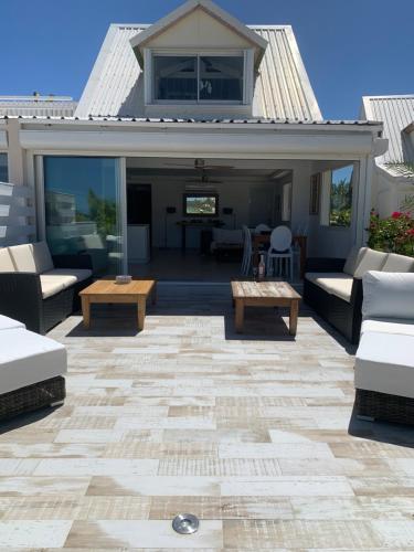 a patio with couches and a table at Coco Beach in Baie Nettle