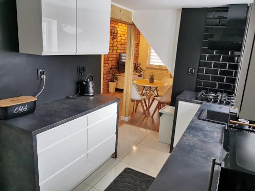 a kitchen with white cabinets and a counter top at Apartament ALPa Kudowa Zdrój in Kudowa-Zdrój