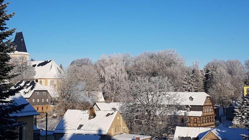 a town covered in snow with houses and trees at Haus Ingrid Ferienwohnung Vintage in Oberlungwitz