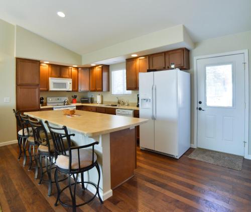 a kitchen with a white refrigerator and wooden cabinets at 1208_Westmoreland in Colorado Springs