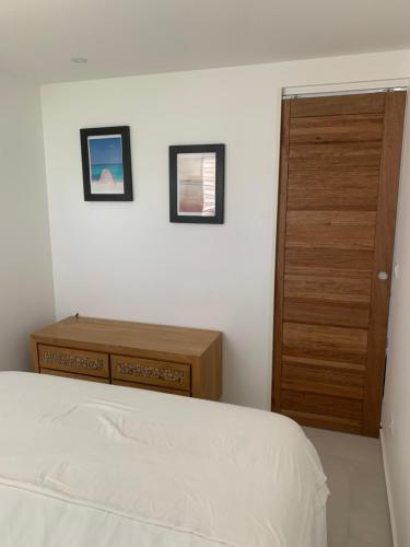 a bedroom with a bed and a wooden door at Coco Beach in Baie Nettle