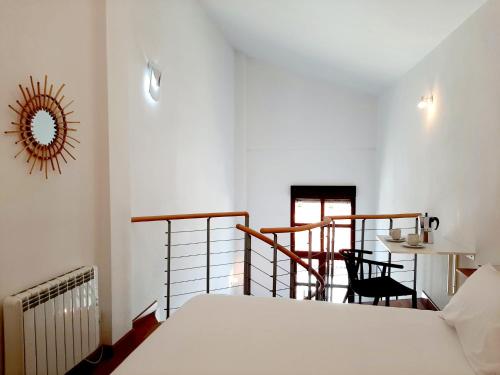 a bedroom with a bed and a table and chairs at Apartamentos Candelario by gaiarooms in Candelario