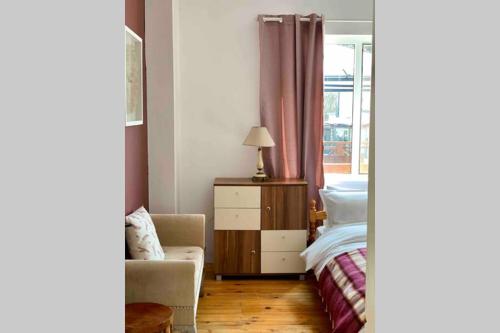 a bedroom with a bed and a chair and a window at Villa Aquila in Beli Iskar