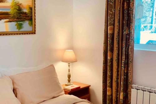 a room with a bed and a lamp and a picture at Villa Aquila in Beli Iskar