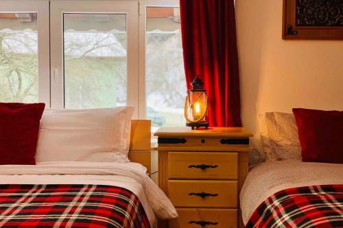 a bedroom with two beds and a lamp and a window at Villa Aquila in Beli Iskar