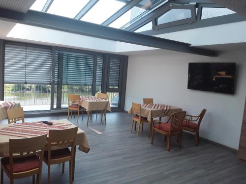 a dining room with tables and chairs and windows at Vierburgeneck in Neckarsteinach