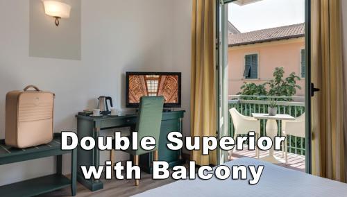 a room with a desk and a balcony with a sliding glass door at Hotel Da Vinci in Montecatini Terme
