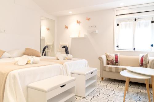 a bedroom with two beds and a couch and a window at Casa Rural Vamos Allá in Campo de Criptana