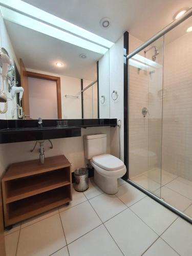 une salle de bain avec toilettes et douche en verre dans l'établissement Flat no Athos Bulcão Executive By Rei dos Flats, à Brasilia