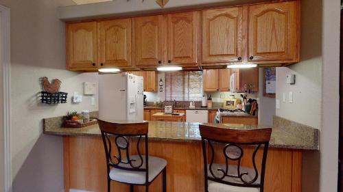 a kitchen with wooden cabinets and a white refrigerator at 120 Winding Meadow by Vacation Rentals for You in Monument