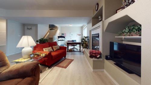 a living room with a red couch and a television at 120 Winding Meadow by Vacation Rentals for You in Monument