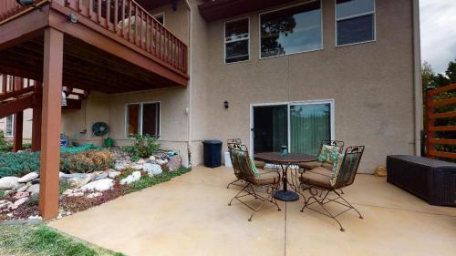 a patio with a table and chairs in front of a house at 120 Winding Meadow by Vacation Rentals for You in Monument