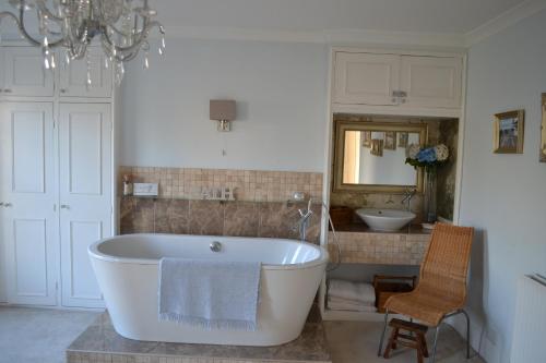 ein Badezimmer mit einer großen weißen Badewanne und einem Waschbecken in der Unterkunft Decimus in St. Leonards