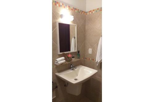 a bathroom with a sink and a mirror at Elephant GuestHouse Beira Mar - Suítes com Café da Manhã in Ilhabela