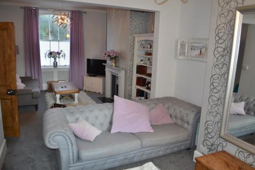 a living room with a gray couch with pink pillows at Decimus in St. Leonards