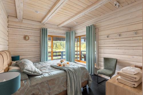 a bedroom with a bed in a room with wooden walls at Koka Maja in Amatciems