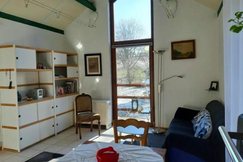 ein Wohnzimmer mit einem Sofa und einem Tisch in der Unterkunft La maison sous les arbres in Gouvy