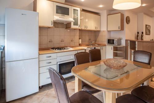 a kitchen with a table and a white refrigerator at Apartment Emilija in Skopje