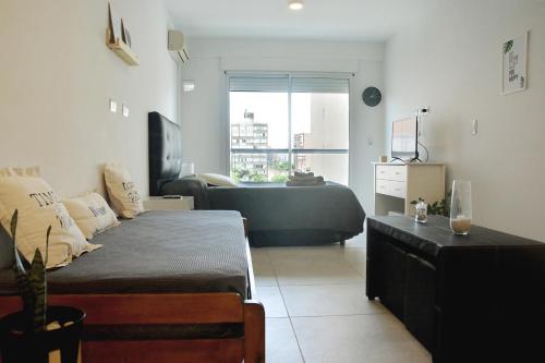 a bedroom with a bed and a large window at Luminosos y modernos departamentos en Rosario in Rosario
