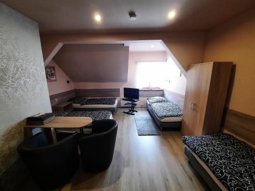 a room with three beds and a table and chairs at Penzion Avena in Stříbro