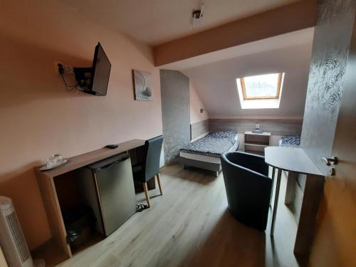 a small living room with a couch and a tv at Penzion Avena in Stříbro