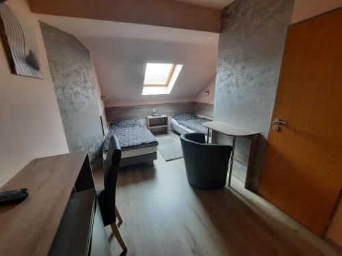 a small room with two beds and a table at Penzion Avena in Stříbro