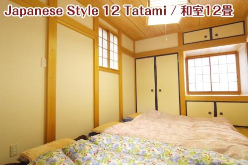 a bedroom with a bed and two windows at NIKKO stay house ARAI - Vacation STAY 14994v in Nikko