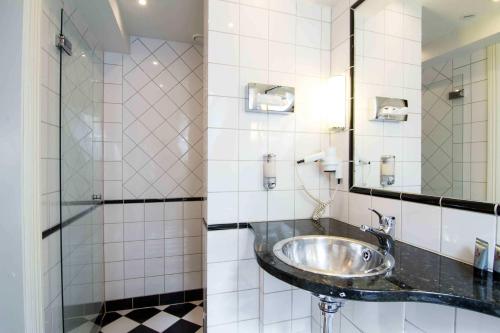 a bathroom with a sink and a mirror at Mayfair Hotel Tunneln in Malmö
