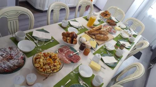una mesa blanca con comida y sillas en Le Relais, en Lavoûte-Chilhac