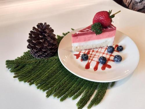 a piece of cake with a strawberry on a plate at Villa PaSon in Khao Kho