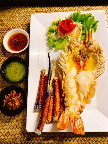 a white plate of food with a shrimp and vegetables at Villa PaSon in Khao Kho