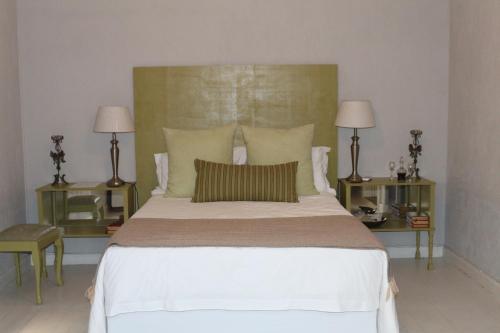 a bedroom with a large white bed with two lamps at GABRIELLA'S in Riebeek-Kasteel