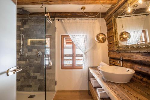 a bathroom with a sink and a glass shower at Obereggeralm in Valdaora