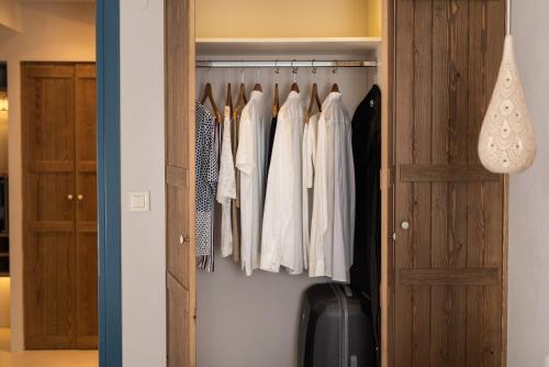 a closet with clothes hanging on a rack at Cretan Soul in Plataniás