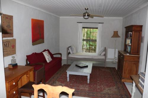 a living room with a red couch and a table at GABRIELLA'S in Riebeek-Kasteel