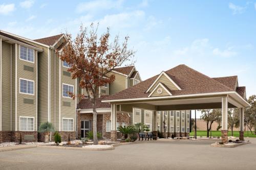 a large building with a pavilion in front of it at Super 8 by Wyndham San Antonio Airport North in San Antonio