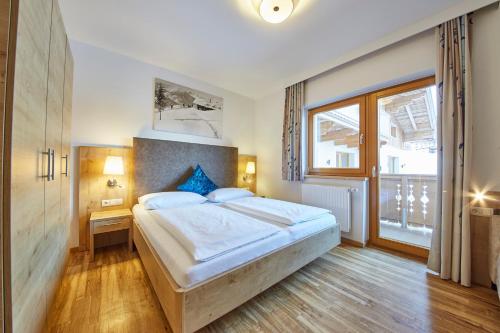 a bedroom with a large bed and a window at Johanneshof - Dein MOUNTAIN Wohlfühlhotel in Saalbach Hinterglemm