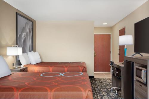 a hotel room with a bed and a flat screen tv at Super 8 by Wyndham San Antonio Airport North in San Antonio