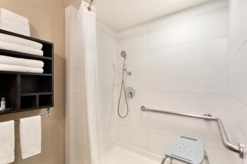 a white bathroom with a shower with a shower curtain at Super 8 by Wyndham San Antonio Airport North in San Antonio