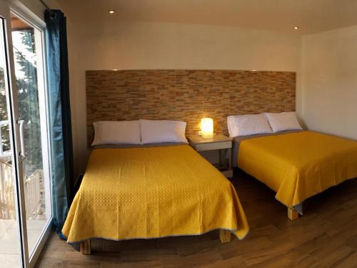 duas camas num quarto com lençóis amarelos em HOTEL COLIBRÍ em Creel