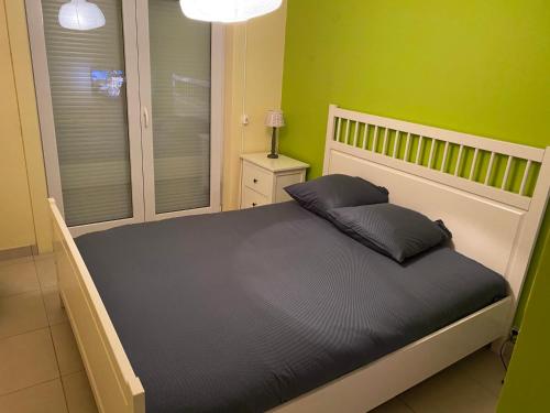 ein Bett in einem Schlafzimmer mit grünen Wänden in der Unterkunft appartement aan zee in Blankenberge