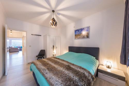 een slaapkamer met een bed met een groene deken bij Ostend Center Parkview Apartment Free Parking in Oostende