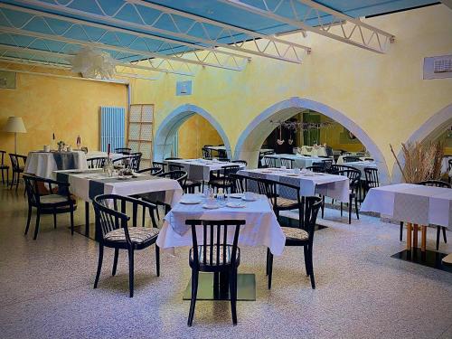a dining room with tables and chairs with white tablecloths at Meister BÄR HOTEL Ostbayern in Floß