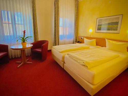 a hotel room with a bed and a table at Meister BÄR HOTEL Ostbayern in Floß
