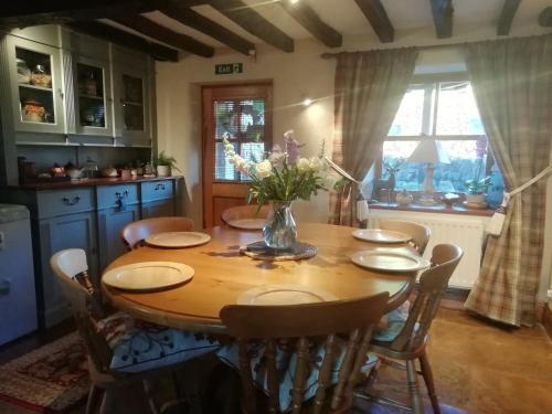 una sala da pranzo con tavolo e sedie in legno di Bollam Cottage Bed and Breakfast a Kirkby Stephen