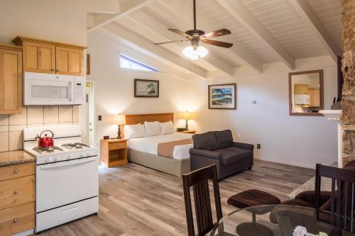 a kitchen and a bedroom with a bed and a table at Andril Fireplace Cottages in Pacific Grove